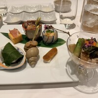 神田明神下 みやび - 左は八寸でホタルイカ、エビ、クラゲ、サヨリ、バイ貝、生ハムなど。右は蛤と山菜のジュレ