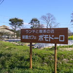 Saienkafepomodoro - 県道沿いの看板で、後ろが畑になっています