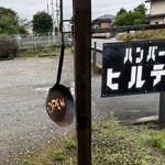 ハンバーグのヒルデン - 駐車場入口の看板の横、黒いフライパンに「OPEN」の白文字