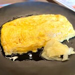 和心だし巻き家 こんび - まず視線を奪われるのは、黒皿の上に鎮座する圧巻のだし巻き玉子。表面は艶やかに輝き、周囲にはじんわりと出汁が広がるビジュアルがたまらない‼️