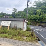 薪窯パン 西の都 - 道路側から見た店舗駐車場の入り口