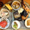 蕎麦割烹 ながの - 前菜。 お見事。 これ目当ての客が多そうでした。 箸をつける前から旨い。 上から時計回りに、蕎麦とキノコのお浸し、素揚げし味噌漬けで焼いた才巻海老、桜海老と蕎麦粉の磯辺揚げ、あん肝、アジなめろう味噌仕立て、トマト、イワシ梅煮、レーズン入り卵焼き、中心がみがきニシンと昆布。 呑兵衛定番かつ季節の品が８種。 どれも和の技が巧みで、季節感満載。 どうすんの、こんなに旨いもんばっかり出して。