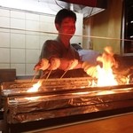 柳家錦 - 店主の林 薫氏が厨房の炭火に対峙しています