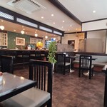 矢馬野 - 店内は白い天井、ガラス張り壁&複数の絵画が飾られた白壁、厨房は緑色のタイル貼り壁、灰紫色のタイル貼り床、ダウンライトの照明、清潔感があり、落ち着いた純喫茶らしい空間、BGMはTV音声