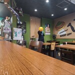 とうちゃんず - 店内は灰色の天井、濃緑色の壁&壁画が描かれた淡いクリーム色の壁、黒塗り土間コンクリート床、化粧合板のカウンター&テーブル、和み感のある空間、BGM代わりTV音声が流れています