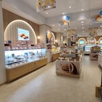 J.sweets Harmony - 店内はクリーム色の天井、クリーム色の壁&飾り化粧合板張りの壁、クリーム色のタイル貼り床、木製の陳列台、ガラス張りショーケース、スッキリとしつつも洋菓子屋さんぽい華やかさも兼ね備えている空間