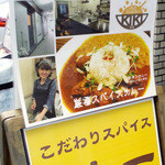 Kiki - 女性店主さんとカレー写真の看板。店前に出ています。