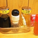 中華そば ムタヒロ - テーブル備え付けの味変アイテム（タレ、黒胡椒、にび酢、唐辛子）