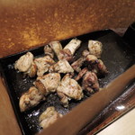 Sumibi Yakitori Gombei - 宮崎県産うなま山地鶏炙り焼き。
      鉄板には鋤の先が使われてるのかな～？
      脂が飛び散らないように紙で覆われてるよ。
      噛めば噛むほど味が出て美味しい地鶏です。