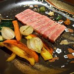 アヴァン プティ・ジョア - で、さっきの肉を使って出てきた料理がこれです。赤牛の葡萄の枝焼きです。お肉と有機野菜のセットになっています。お皿もお洒落で華がありますよね。