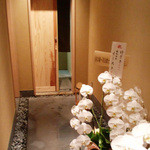 竹ざき - アプローチとお祝いの花。引き戸の向こうは吹き抜け