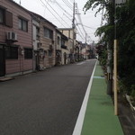 お店の前の通り。左側の電柱の後ろです。