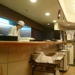 Chika Guriru - テーブル席から厨房を見る。(カウンター内で麺類を造り、ステンレス壁を隔てた裏側でご飯物が作られる。)