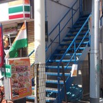 サンライズ - セブンイレブン横の青い階段を上がるとお店。