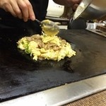 京 - 生地の上にホルモンをのせまた焼きます。