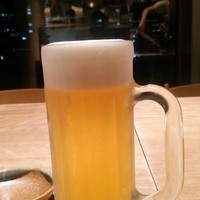 くし路 KITTE丸の内店 - 生ビール。窓の外には丸の内のビル群の夜景。