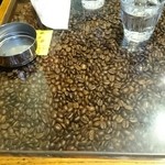 ぽえむ マノ ア マノ コーヒー - コーヒー豆が敷き詰められたテーブル