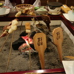 本家伴久 - 囲炉裏端には名物「一升べら/岩魚/板台餅/厚揚げ/雉焼き」が並びます(2015.Nov)