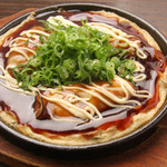 Grilled oysters on a teppanyaki plate with green onions