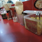 家系ラーメン とらきち家 - 卓上には調味料がいっぱいあるよｗライス用のニンニクまである。