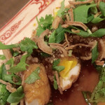ハノイ・カフェ - ゆで卵を揚げてカットしソースをかけて　フライドオニオン・パクチーが乗っています