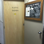 sync - 階段を上がった2階にお店の入り口扉があります。