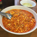 味芳斎 - 注文したのはこちら。「麻婆豆腐丼」こちらのお店の名物の１つ。ご飯は麻婆豆腐の下に隠れてて見えません。豆腐は細かく、色は鮮やかなオレンジ色‼︎
シルバーのレンゲが添えられています。