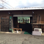 外観。シンプルな平屋。トレードマークの緑の暖簾。