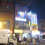 ナングロガル - 通り向かいから。3・4Fに電飾と看板が見える。5Fにはネパール国旗