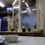 Minatoshokudou - 店内の雰囲気です。店内はテーブル席とカウンターから構成されています。テーブル席は３つです。カウンターは写真で写っているようにＬ字型になっています。