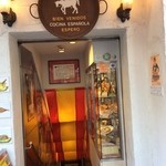 スペイン料理銀座エスペロ - 【３】地下のお店に続く階段。天井にスペインの国旗色！壁に料理の模型が飾られています。