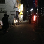 麺や　まるしょう - 終電間際の線路沿いに眩しく輝くサイン。手前の酒場もとっくに閉まっている。