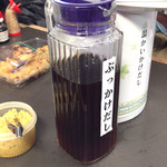 日の出製麺所 - 机の上に出汁と薬味があります。