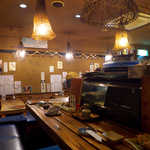 暗めの照明で落ち着く店内。カウンターで一人呑みも良し、テーブルで楽しむも良し