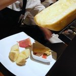 プティ・カッセ - さあ、チーズが暖まりました。チーズのいい匂いがお店に充満しています。チーズを傾けてジャガイモにたらすところです。