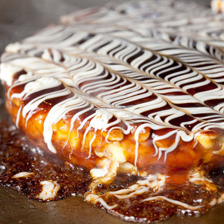 Exquisite Okonomiyaki cooked piping hot on a griddle by a skilled chef!