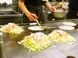 Okonomiyaki Mitchan Sohonten - 鉄板でお好み焼きが焼かれていく