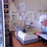 木村屋 - レジ横　レジを打つ店主と壁の芸能人サイン色紙