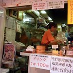 台湾の焼き包子 包包亭 - お店の前まで行きました。 天井の所に沢山のサインがありますね。 誰のかはサッパリ分かりませんが。 中は３名体制で作業していましたよ。 蒸したりしているので中は相当暑いでしょうね。