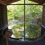 露天風呂。超絶技巧で作られた石の浴槽に新緑が映り込む。4人程入ることのできる広さ