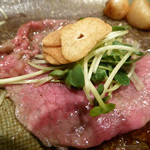 シャカ - 牛肉の薄切り。ニンニクチップを包んで食べる