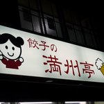 満州亭 - お店の看板です。 餃子の満州帝と書いてあります。 そして、左側に中国の女の子の絵が右に生ビールが描かれています。 とっても可愛らしい雰囲気の看板ですね。