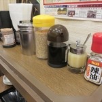 まるうまラーメン - 生ニンニク、白ごま等テーブル上、トッピングも充実