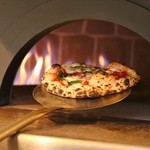 Chewy Neapolitan-style pizza margherita baked at a high temperature of 500 degrees.