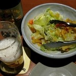 くいもの屋わん - お通しのサラダとぬる過ぎて泡ばかり立ってしまう瓶ビール。