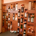 鳥と魚 - 小上がり座敷の壁には日本酒＆焼酎の一升瓶が飾られています♪
