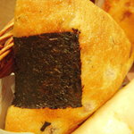 ドンク - これがおにぎりパン。醤油味のモッチリしつつしっかりした歯ごたえのするパンです。黒い巻物はもちろん海苔。