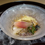 富小路 やま岸 - 蓮の葉から下のガラスの器に素材を移す演出　器の中には糸瓜や平貝が隠れていました