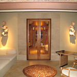 Amankila - テラスのソファーベッドとテーブル、バリの白い花を持つ壁の守り神