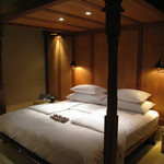 Amankila - バリ意匠の天蓋付きベッド。ベッドの上にはバティックとスイーツのプレゼント